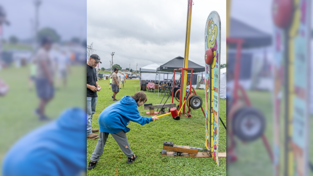 Photo by Gwen Sour | Mitchell Townsend, a Parkersburg resident, swings down a hammer at one of the games offered during the Freedom Festival this weekend.