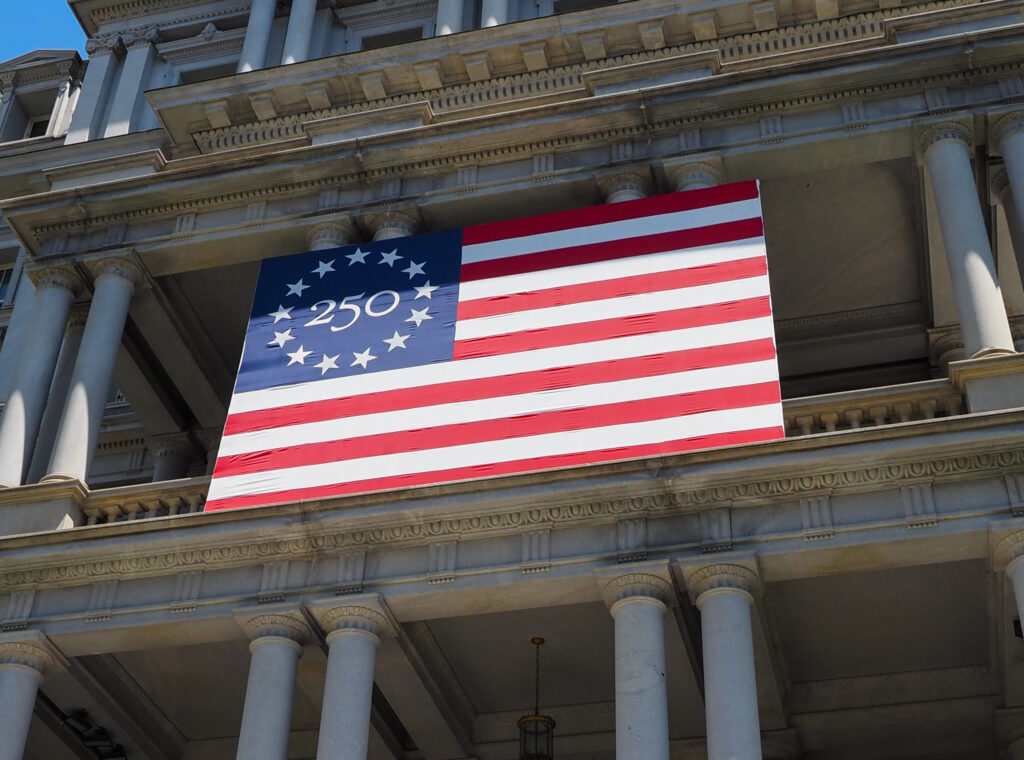 A 250th anniversary flag on the Dwight D. Eisenhower Executive Office Building, location of the vice president’s office, on 17th Street NW in Washington, D.C., on Tuesday, May 5, 2026 (Photo by Ashley Murray/States Newsroom)