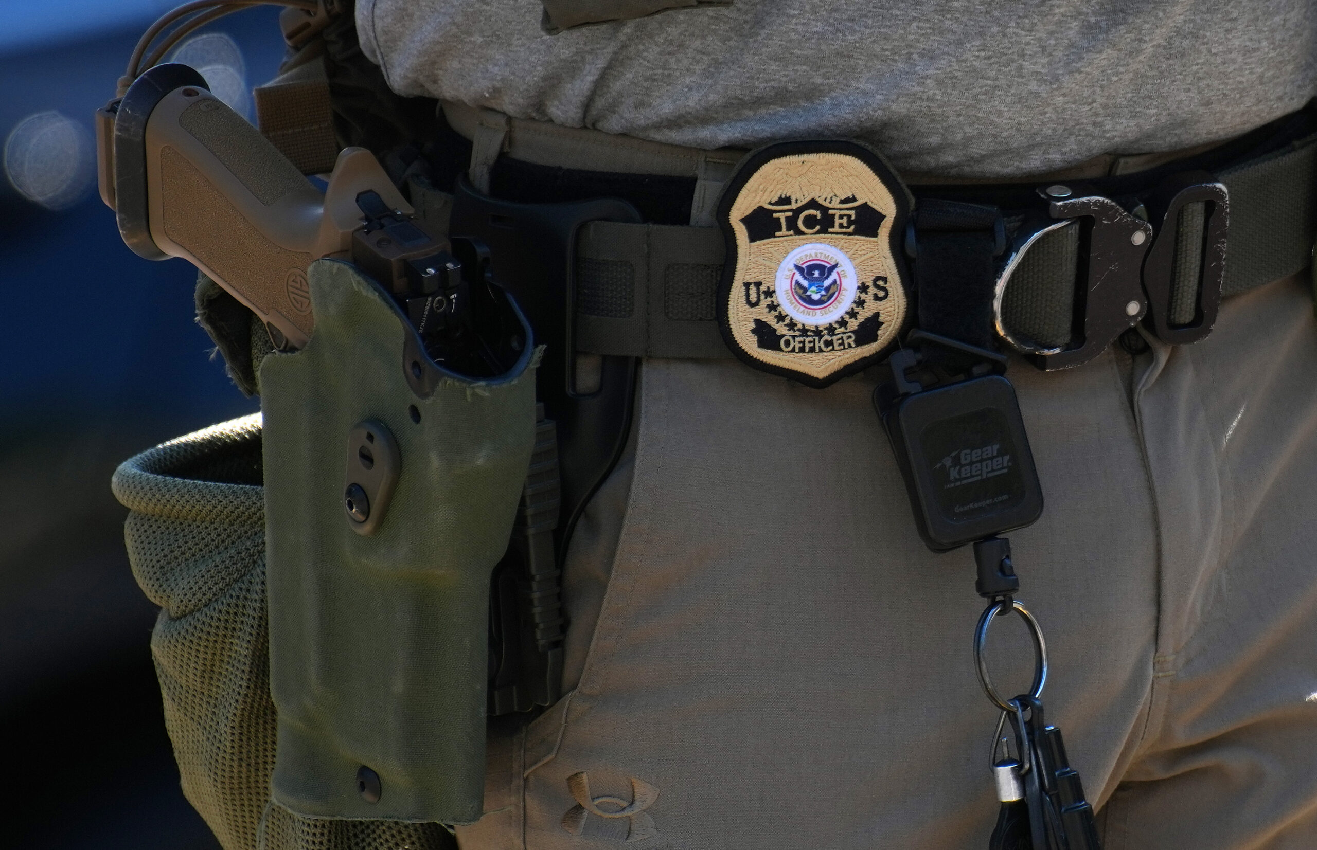An Immigration and Customs Enforcement (ICE) officer's badge and weapon are seen as ICE conducts a vehicle checkpoint on Georgia Ave. on August 30, 2025 in Washington, DC. The Trump administration has deployed federal officers and the National Guard to the District in order to place the DC Metropolitan Police Department under federal control and assist in crime prevention in the nation's capital. (Photo by Kevin Dietsch/Getty Images)